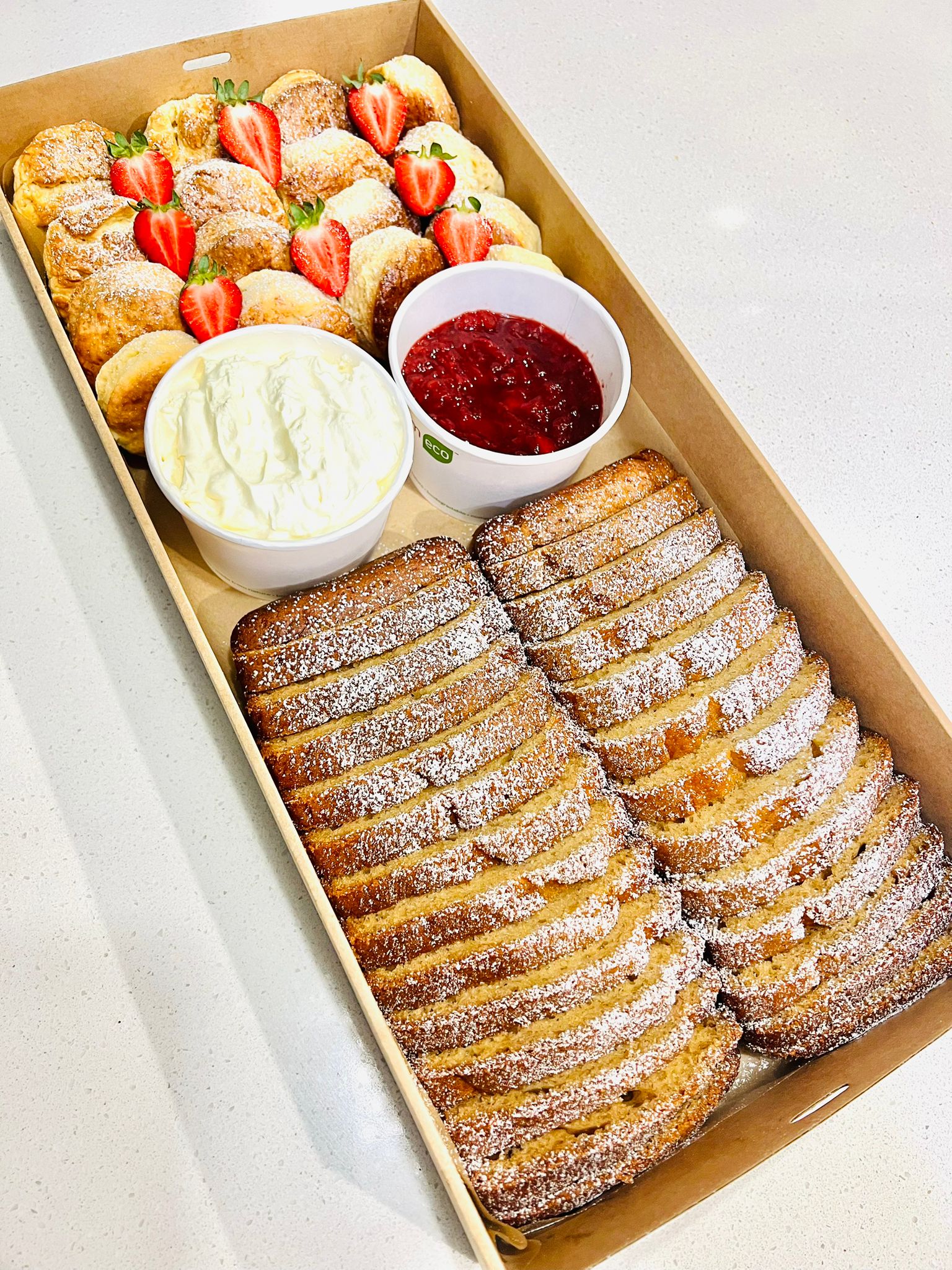 Scones and banana bread box with cream and jam