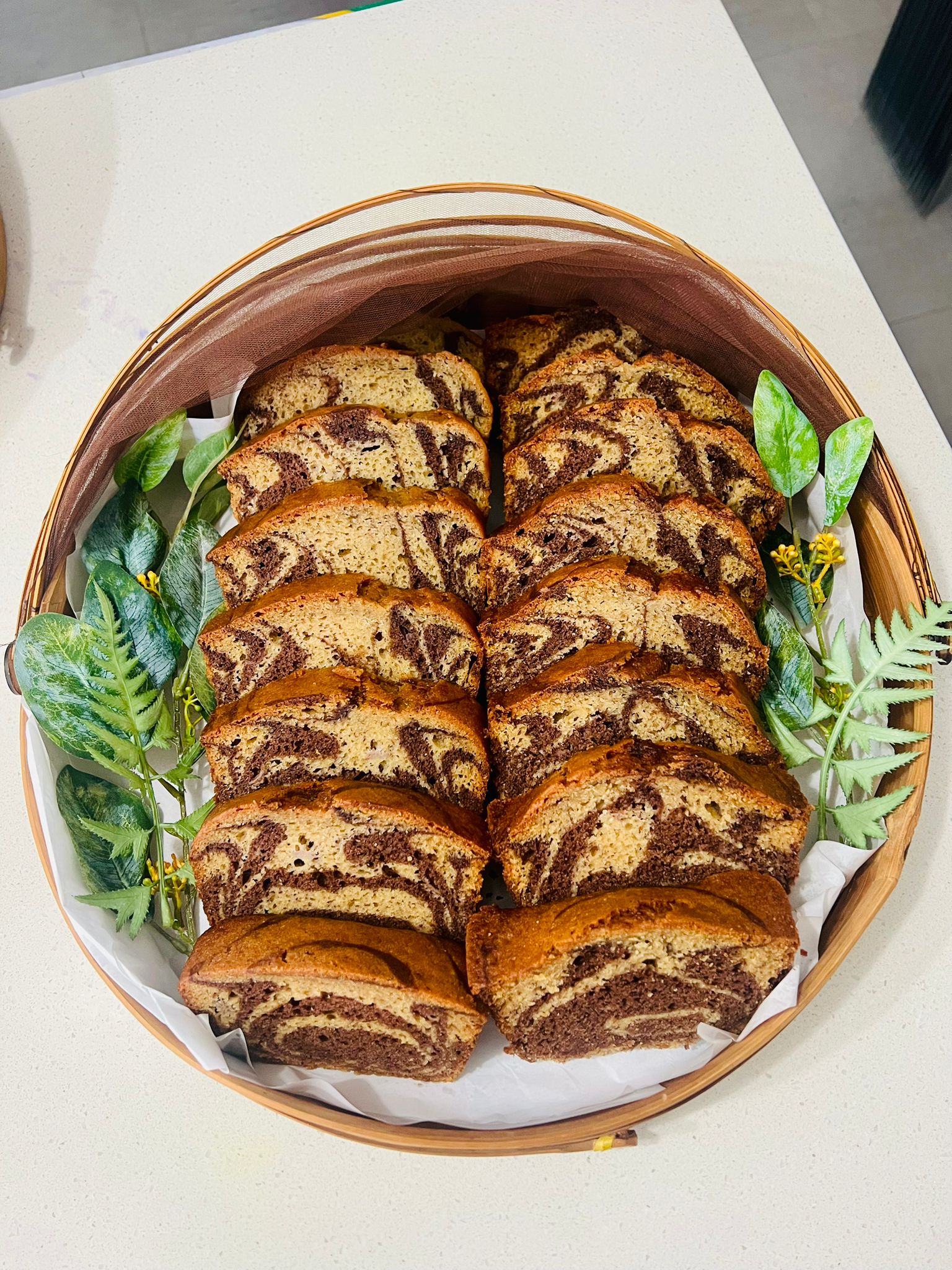 Chocolate marble banana bread loaf — sliced and arranged in a round bamboo basket